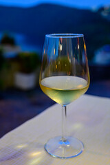 Glass of cold dry white wine served outdoor in cafe at night in Italy