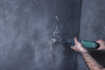 The Builder makes a hole in the wall with a hammer