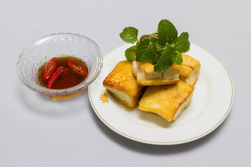 fried tofu blocks and fish sauce on white background