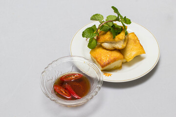 fried tofu blocks and fish sauce on white background