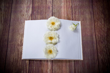 Fototapeta premium bouquet of beautiful white roses and blank notebook