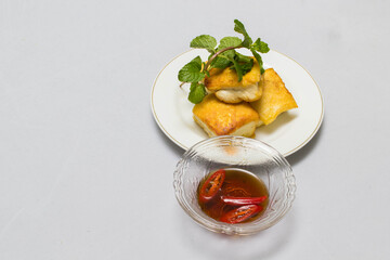 fried tofu blocks and fish sauce on white background