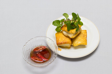 fried tofu blocks and fish sauce on white background