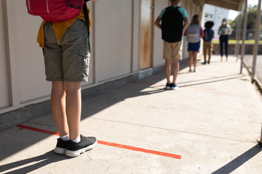 Rear View Of Group Of Kids Maintaining Social Distancing At School