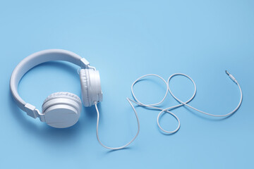 White headphone on blue background. Music concept.