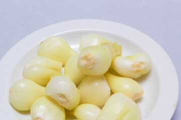 three pickled onions with parsley on white background