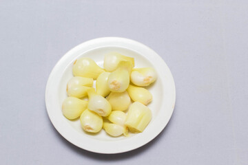 three pickled onions with parsley on white background
