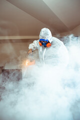 .a professional disinfects the room with an antiseptic