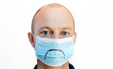 Man wearing a face mask with a sad smiley face, isolated on white background.