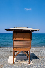 Fototapeta na wymiar Wooden lifeguard safety station against blue water and sky