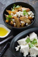 Greek style potato wedges with feta cheese and olive oil, vertical shot, selective focus