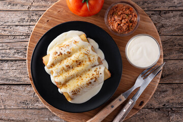 Delicious meat cannelloni pasta on rustic wooden table. Top view