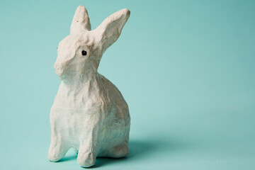 Festive white rabbit toy on a blue background with pastel colors Easter