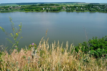 a soulful walk along a wide wilderness along a deep river in the midst of a sunny summer.