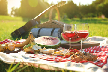 Picnic blanket with delicious food and drinks outdoors on sunny day