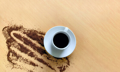 Taza blanca de café caliente sobre la mesa de madera rodeada de café