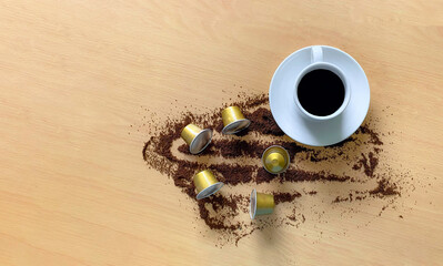  Taza blanca de café caliente sobre la mesa de madera rodeada de cápsulas y grano de café