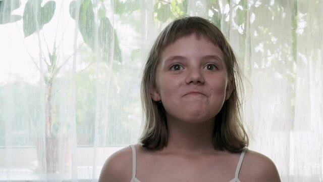 Little eight-year-old caucasian girl grimaces in front of camera. Mind blown reaction of little girl expressing her shock of something unbelievable. excited girl showing gesture of brain explosion