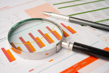 Magnifying glass on charts graphs paper. Financial development, Banking Account, Statistics,...