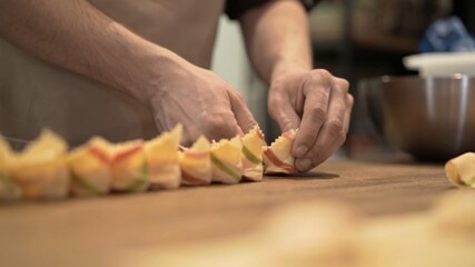 Male hands laying tortellini on wooden tray, on wooden kitchen table close up. Male hands cooking italian food, handmade tortellini at the restaurant kitchen