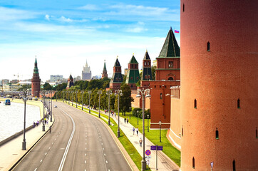 Obraz premium View of the empty Kremlin embankment with the fortress wall and towers of the Moscow Kremlin on a clear sunny day. Sights of Russia, a historical building, symbol of the country.