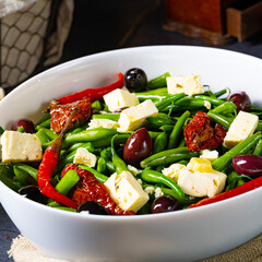 Spicy green bean salad with olives, feta cheese and dried tomatoes