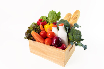 Wooden crate with multi color vegetables , fruit, milk and baguette isolated on white bakcground. Grocery in wood crate . Save with clipping path