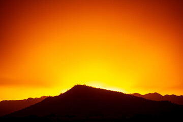 A dramatic cloudy sunset in the desert of Arizona with mountains.