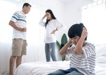 Crying illtle asian boy with his fighting parents in the background, Family problems, Divorce problem.