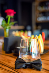 Empty glass with bow tie on table