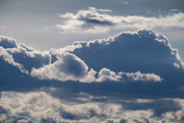 Dark blue sky on which there are contrast blue clouds, abstract background