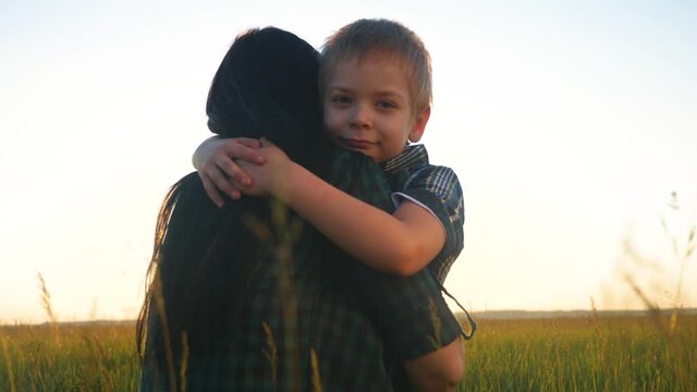 son hugs mom. concept happy family teamwork. boy kid hugs beloved mother sunlight at sunset. Womens day concept. parent girl have a tender lifestyle relationship are in love