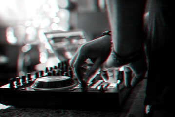 hands DJ playing and mixing music on music controller at a party