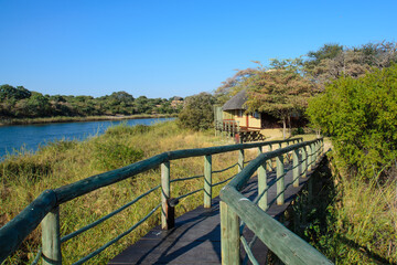 Fototapeta na wymiar Afrika - Holzbrücke am Kawango / Okawango in Namibia nah Rundu und Blick auf ein angolanisches Dorf am anderen Ufer des Flusses