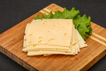 Sliced yellow cheese over board