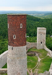 Dwie wieże Zamku w Chęcinach, ceglasto-kamienna okrągła i prostokątna kamienna, z otaczającym je murem, na tle lasów, pól i pagórków aż po horyzont © Agnieszka