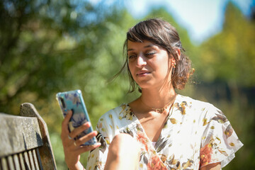 young woman using a phone in a park