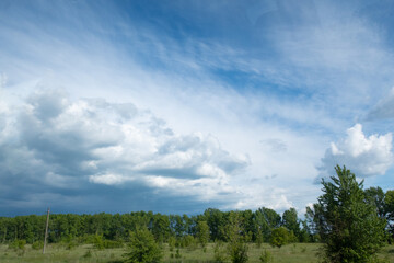 Fototapeta premium Beautiful storm clouds over a green field.