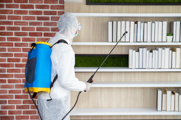 Male medical staff wearing PPE uniforms to prevent COVID-19 from using a nebulizer. And use chemicals to disinfect at the library, reading room, to prevent the risk of coronavirus outbreak.