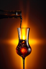 Pouring an alcoholic beverage into a steamed glass with natural ice.
