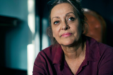 Close-up of thoughtful senior woman looking away while sitting at home