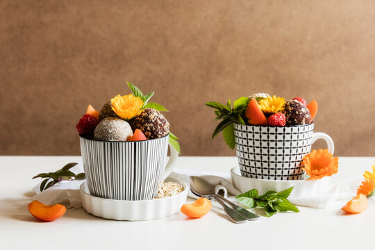 Dessert with energy balls (raw confectionery) and fresh fruits and flowers
