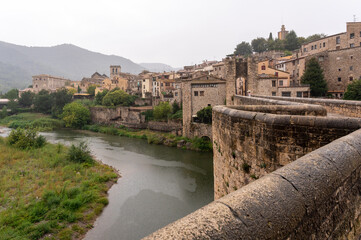 Fototapeta na wymiar Medieval village in the rain, view of the river from a bridge