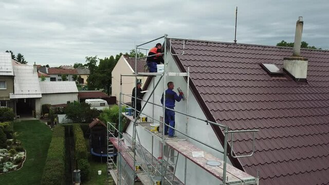 Workers to renovate a house. Aerial shot of thermal insulation of the facade of a family house.