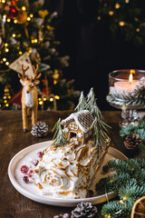 Christmas dessert, meringue roll decorated with gingerbread house, bokeh lights