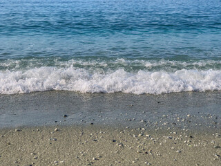 waves and sand on the beach close-up across the horizon. Seaside background. Copy space