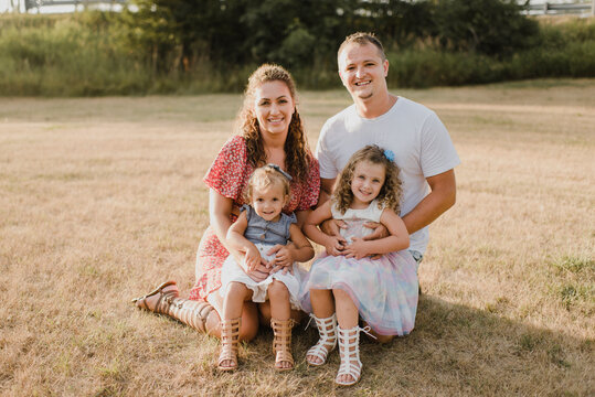 Portrait of smiling parents with two daughters on a meadow