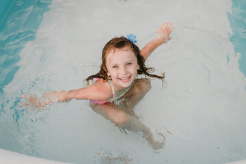 Portrait of a happy girl in an inflatable swimming pool