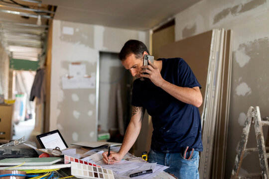 Man on the phone working on construction plan