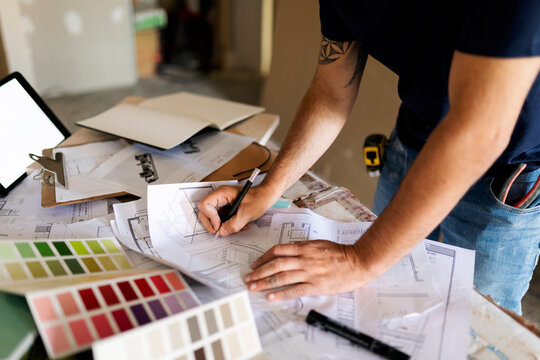 Man working on construction plan and colour swatch